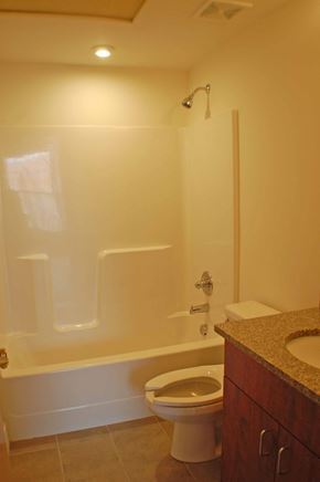 Richmond apartment for rent - A white toilet is in a bathroom with a walk-in shower.