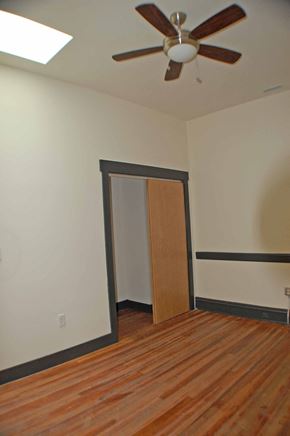 Richmond apartment for rent - A room with a ceiling fan and a wooden floor.