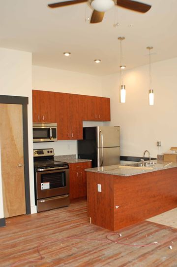 Richmond apartment for rent - A kitchen with wooden cabinets and a refrigerator.