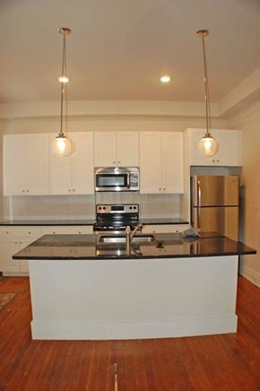 Richmond apartment for rent - A kitchen with a black counter top and white cabinets.