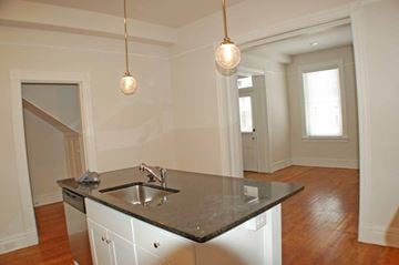 Richmond apartment for rent - A kitchen with a black counter top and white cabinets.