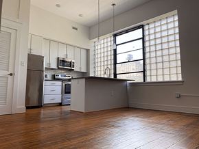 Richmond apartment for rent - A kitchen with wooden floors and a window with blinds.