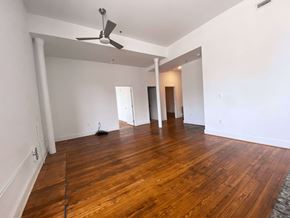 Richmond apartment for rent - A room with a ceiling fan and wooden floors.