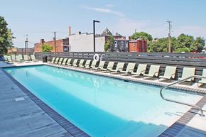 Richmond apartment for rent - A large swimming pool with sun loungers on the side.
