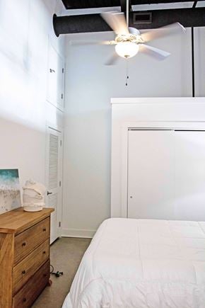 Norfolk apartment for rent - A bedroom with a bed, dresser, and ceiling fan.