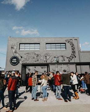 Norfolk apartment for rent - A group of people are standing in front of a building with a mural of a snake on it.