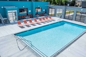 Norfolk apartment for rent - A swimming pool with red chairs around it.