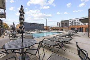 Richmond apartment for rent - A poolside area with a table and chairs.