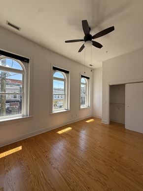 Richmond apartment for rent - A room with a ceiling fan and wooden floors.