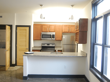 Suffolk apartment for rent - A kitchen with a white counter and wooden cabinets.