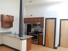 Suffolk apartment for rent - A kitchen with a stove top oven and a refrigerator.