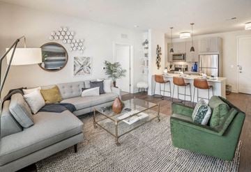 Princeton apartment for rent - A modern living room with a grey sofa and a green armchair.