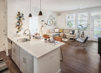A modern kitchen with a white countertop and a sink.