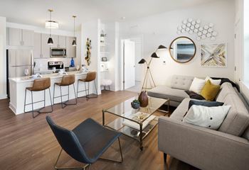 A modern living room with a grey sofa and a black chair.