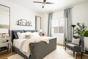 Glendale apartment for rent - a bedroom with a bed and a chair and a ceiling fan at Onyx at Westgate Apartments, Glendale, AZ, 85305