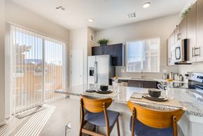 Brighton apartment for rent - a kitchen and dining area with a glass door to a balcony at The Villas at Prairie Center, Brighton, CO, 80601