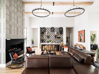 A living room with a brown leather couch and a fireplace.