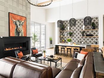 A living room with a fireplace and a painting of a bull on the wall.