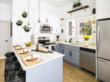 A kitchen with a white countertop and a refrigerator on the right.