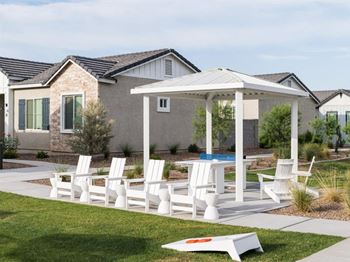 A white patio set is in front of a house.