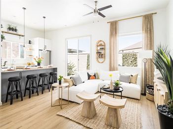 A modern living room with a bar area and a kitchen in the background.