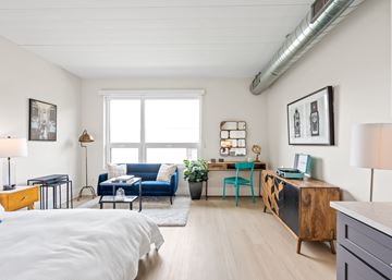Chicago apartment for rent - A living room with a blue couch and a white bedspread.