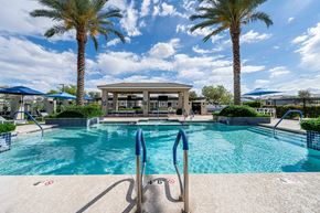 Tolleson apartment for rent - A pool surrounded by palm trees and a pavilion. at Vistoria At Country Place Apartments, Tolleson