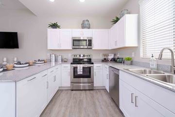 Tolleson apartment for rent - A modern kitchen with white cabinets and stainless steel appliances.