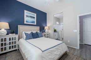 Tolleson apartment for rent - A bedroom with a white bed and blue accents. at Vistoria At Country Place Apartments, Tolleson, AZ, 85353