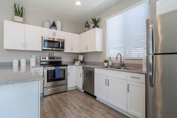 Surprise apartment for rent - A kitchen with white cabinets and stainless steel appliances.