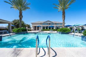 Surprise apartment for rent - A swimming pool surrounded by palm trees and a building in the background at Vistoria At Marley Park Apartments, Arizona, 85379