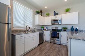Surprise apartment for rent - Modern kitchen with white cabinets and granite countertops at Vistoria On Mountain View Apartments, Arizona