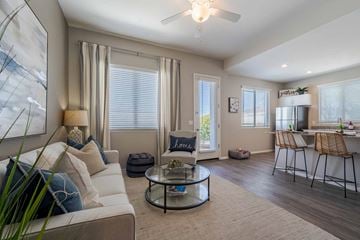 Surprise apartment for rent - A living room with a white couch, a glass coffee table, and a painting on the wall.