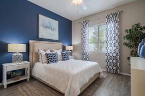Peoria apartment for rent - A bedroom with a bed, nightstand, and a painting on the wall.