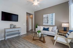 Peoria apartment for rent - A living room with a white couch, a television, and a coffee table.