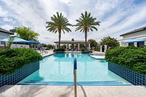 Peoria apartment for rent - A swimming pool surrounded by palm trees and a blue sky.