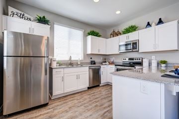 Litchfield Park apartment for rent - A kitchen with white cabinets and a stainless steel refrigerator.