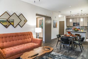 Melbourne apartment for rent - A living room with a red couch and a dining table with chairs.