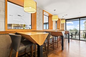 Lakewood apartment for rent - a dining area with wooden tables and chairs and a large window with a view of the outdoors at Union West Apartments, Lakewood, 80228
