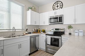Goodyear apartment for rent - a kitchen with stainless steel appliances and white cabinetry at Soleil at Canyon Trails Apartments, Arizona