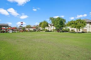 Goodyear apartment for rent - a large lawn with houses in the background at Soleil at Canyon Trails Apartments, Arizona