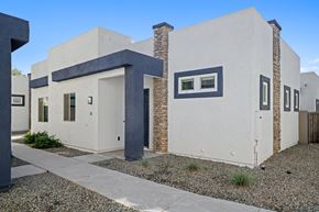 Queen Creek apartment for rent - the front of a white house with blue trim and a sidewalk at Olive Queen Creek Apartments, Queen Creek, AZ, 85142