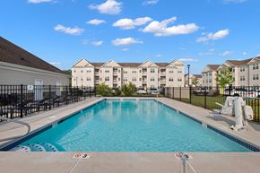 Hazlet apartment for rent - a swimming pool with apartment buildings in the background at The Landing Apartment, Hazlet, NJ, 07730