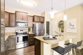 Maple Grove apartment for rent - a kitchen with stainless steel appliances and a granite countertop at Skye at Arbor Lakes, Maple Grove, Minnesota