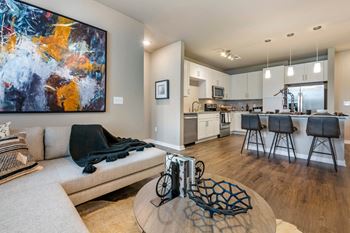 A modern living room with a large abstract painting on the wall.