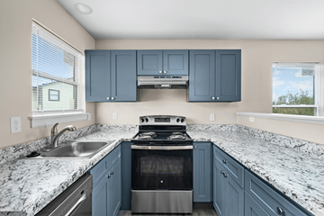 Oklahoma City apartment for rent - A kitchen with blue cabinets and granite countertops.