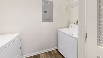 A small laundry room with a washer and dryer and a laundry room door