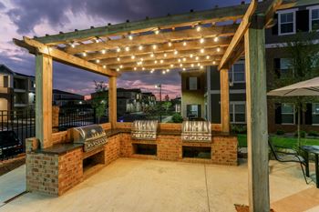 Grilling stations under pergola at dusk