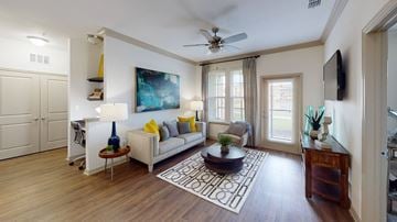 Winter Springs apartment for rent - A living room with a white couch, a blue vase, and a painting on the wall.