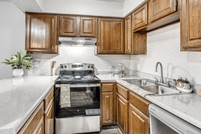 Oklahoma City apartment for rent - a kitchen with wooden cabinets and a stove and a sink at Diamond Ridge Apartments, Oklahoma City, OK